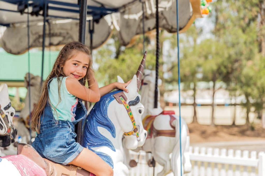 A girl riding the carousel at Rydges Resort Hunter Valley. Image Hamilton Lund