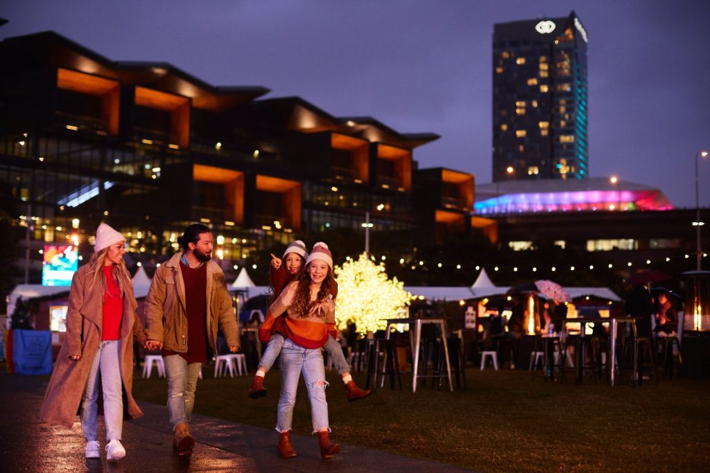 Family enjoying the Darling Harbour Winter Festival night market. Image Destination NSW