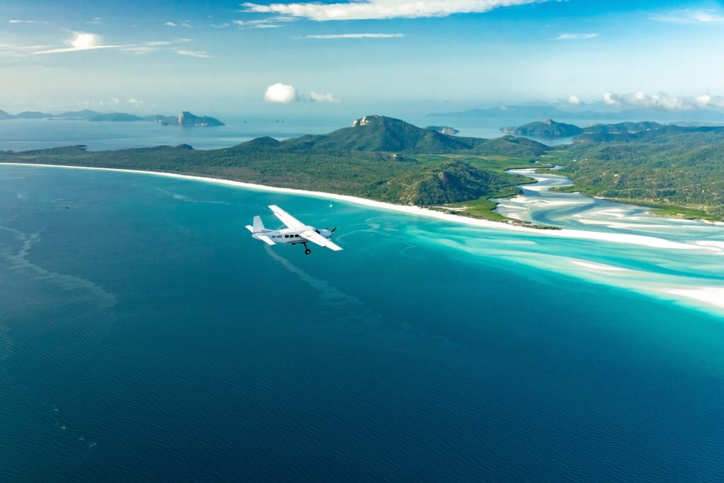 Plane flying over Whitehaven Beach on a Whitsundays scenic flight. Image Tourism and Events Queensland