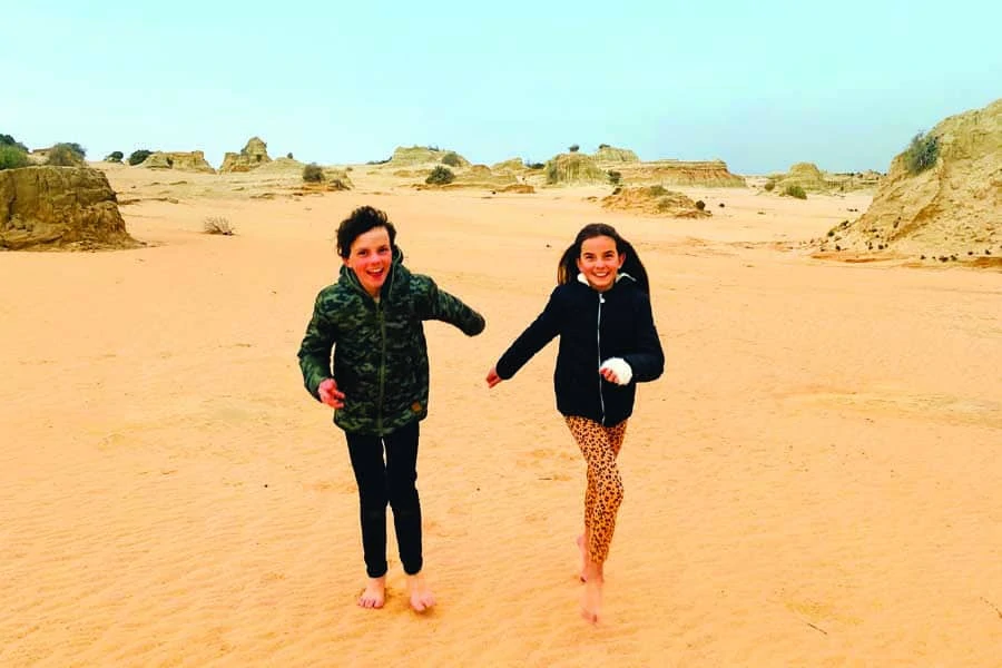 Maya and Remy running among the Walls of China in Mungo National Park