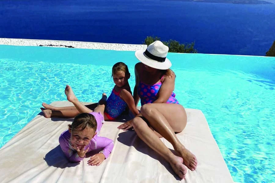 relaxing by the pool at adronis luxury suites located cliffside in santorini