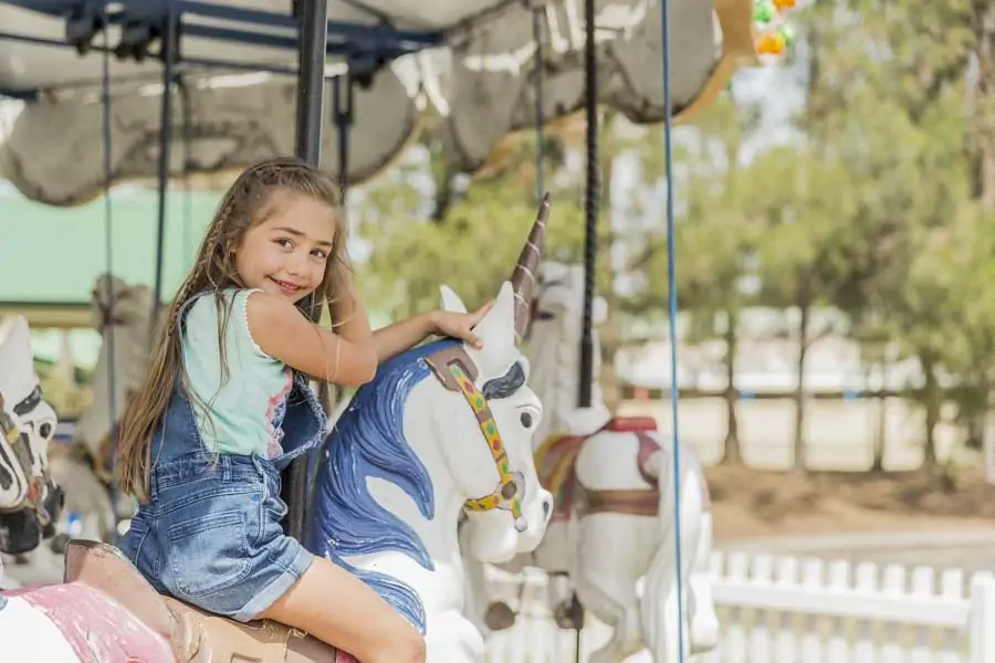 a girl riding the merry go round at crowne plaza hunter valley