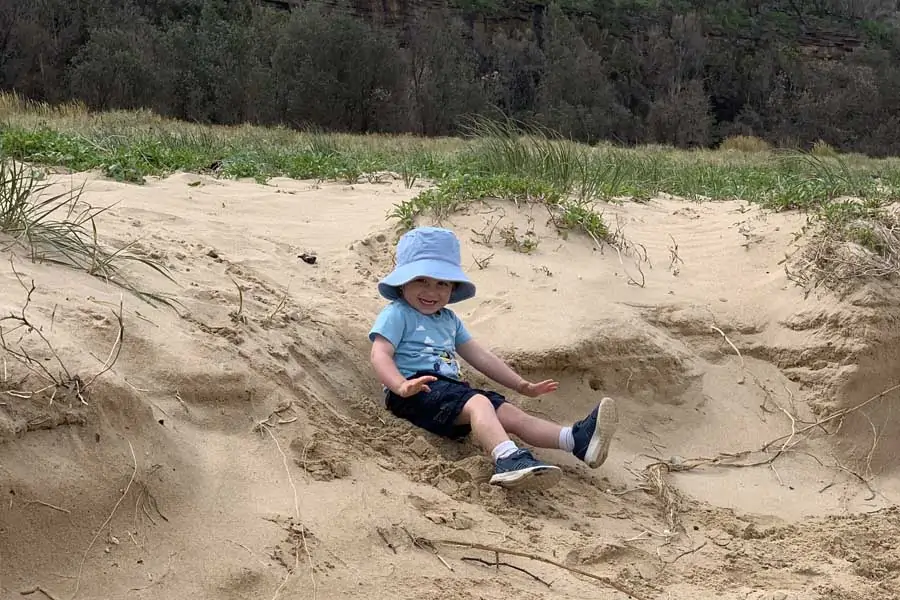 oliver sliding down the dunes at durras beach