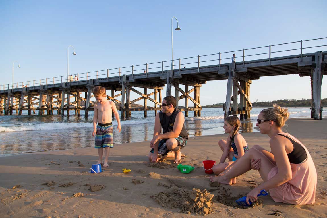 FEATURE A family playing in the sand near Coffs Harbour jetty. Image Destination NSW