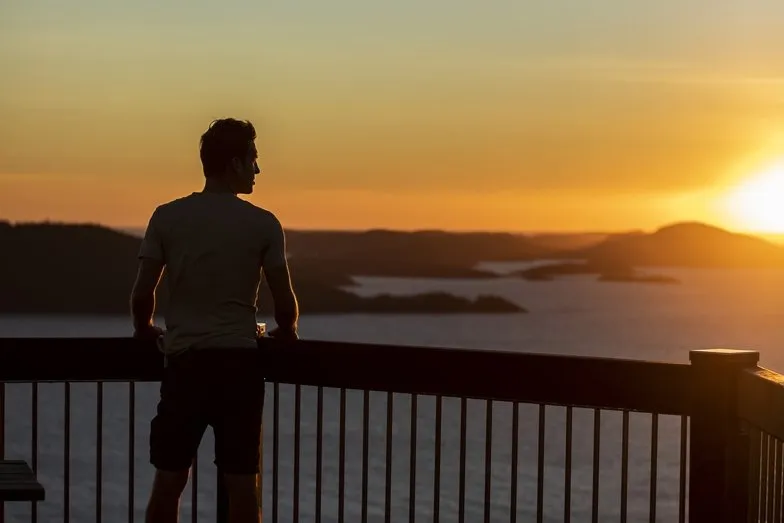 A man taking in the view from Passage Peak on Hamilton Island. Image Destination NSW