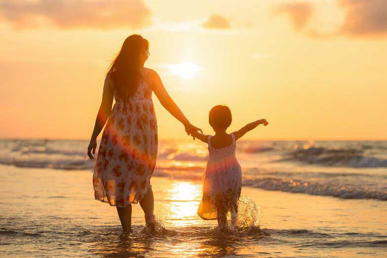 Mother and daughter by the beach