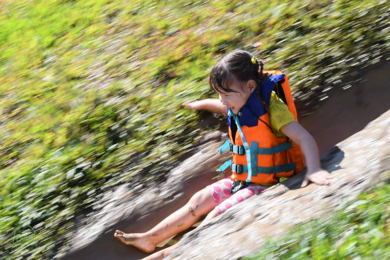 A girl sliding down the mudslide at the Ginger Farm