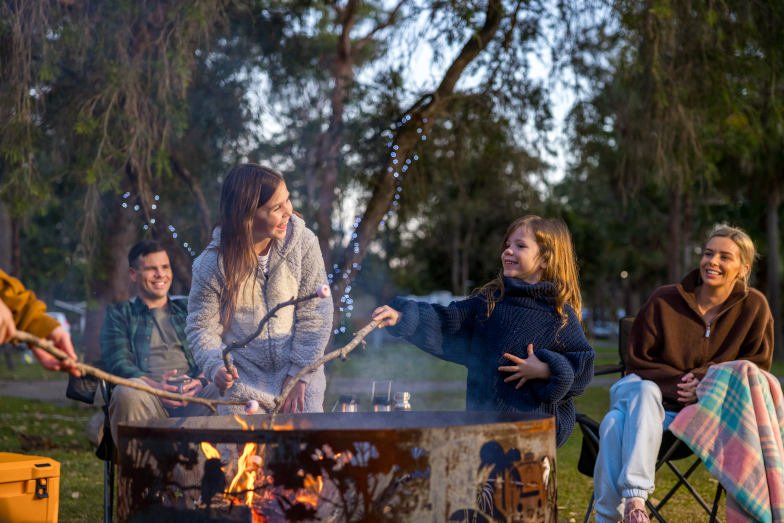 A family toasting marshmallows at NRMA Darlington Beach Holiday Park near Coffs Harbour