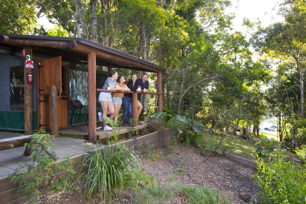 Family standing on the verandah of their Safari Tent at Binna Burra Lodge. Image Tourism and Events Queensland